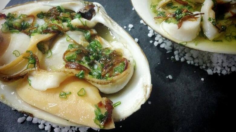 Steamed Atlantic surf clams against a black background