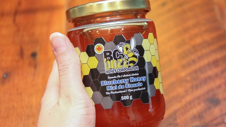 hand holding jar of blueberry honey