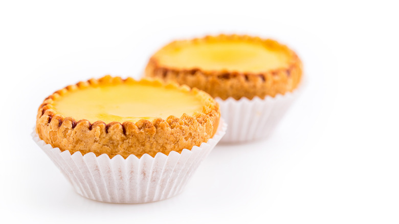 Delicious freshly baked egg tarts on white background