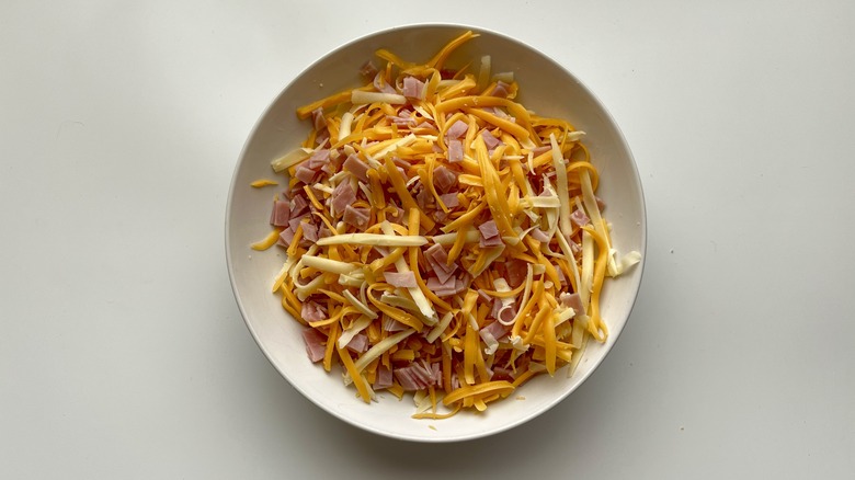 chopped ham and shredded cheese in a white bowl