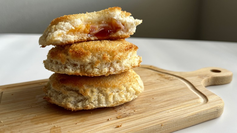 circular, jelly-filled sandwiches on a wooden board