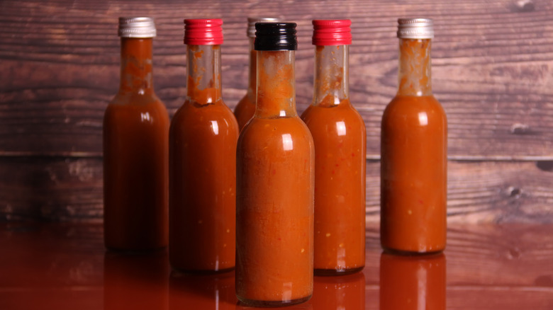 bottles of unlabeled hot sauce on a table