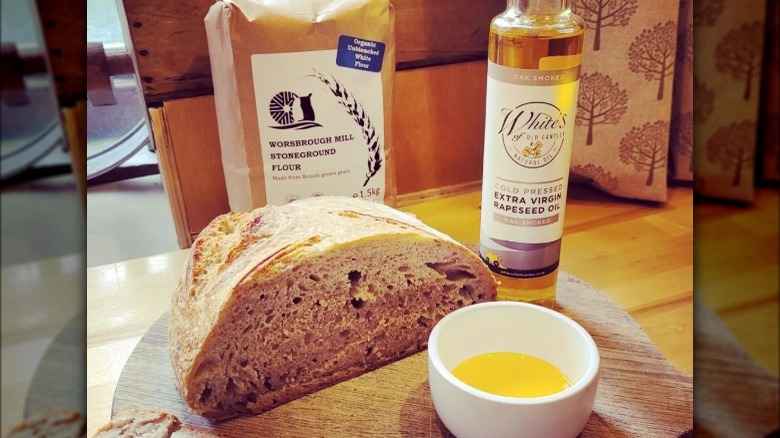 Cold pressed rapeseed oil bottle, bread, and oil dipper