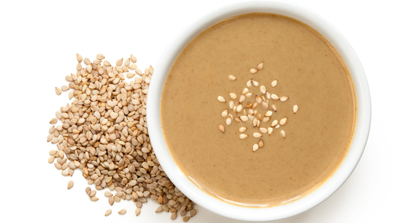 Tahini in bowl with sesame seeds