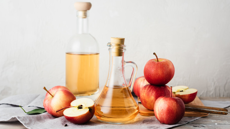 Apple cider vinegar bottles with apples.