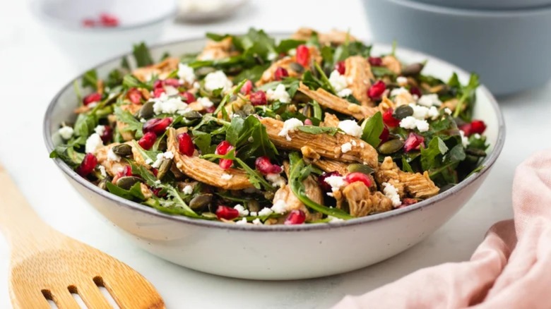 Pomegranate chicken salad in white bowl