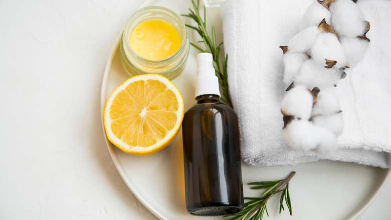 Spray bottle with cotton balls, rosemary, and lemon