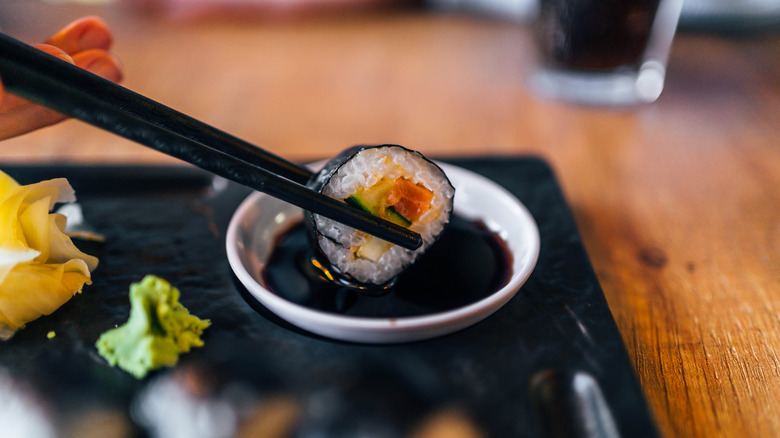 dipping sushi into soy sauce