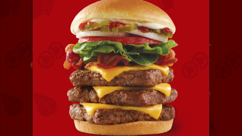 A Triple Bacon Burger from Wendy's is shown on a red background.