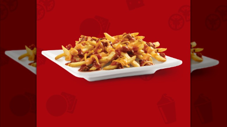 Chili Cheese Fries from Wendy's on a white plate with a red background.