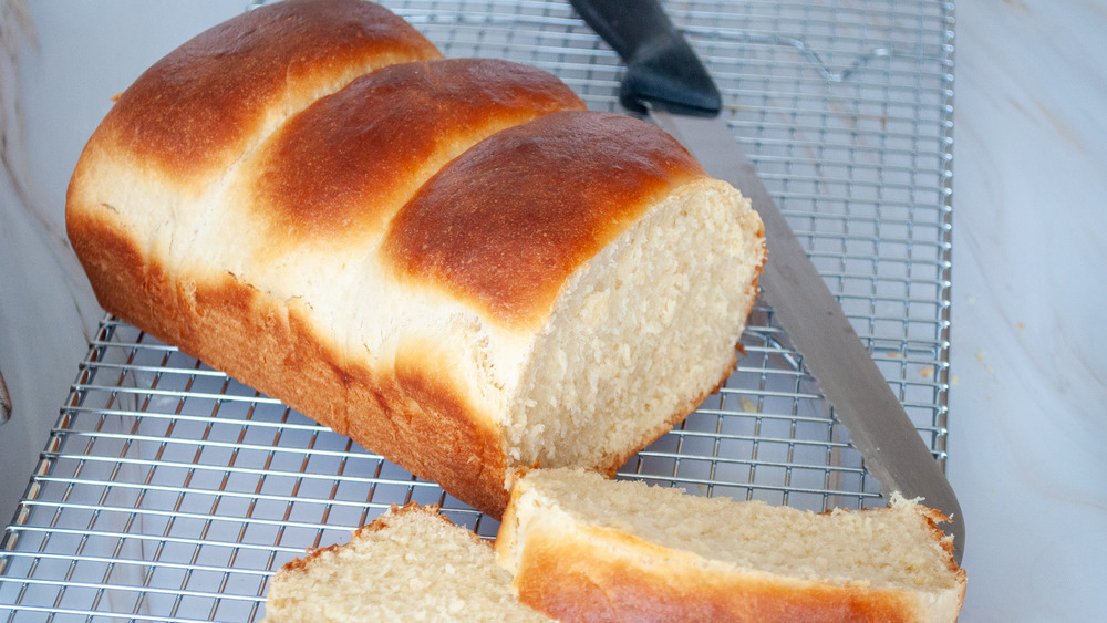 loaf of sliced milk bread on a wire cooling rack