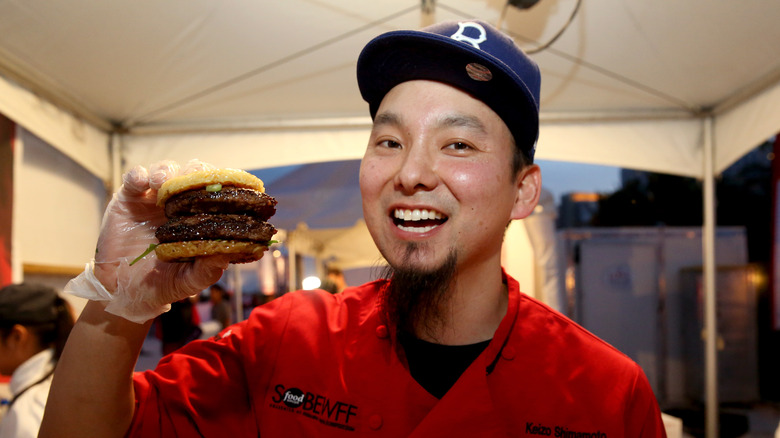 Keizo Shimamoto clutching a ramen burger