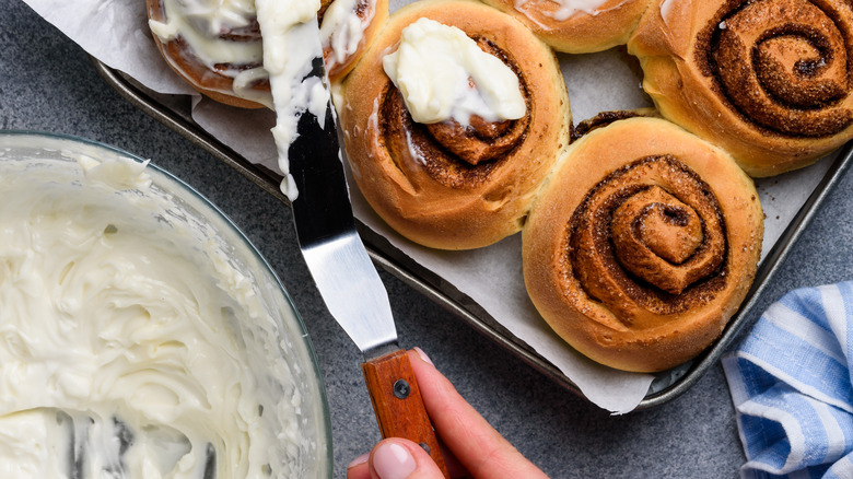 Frosting spread on cinnamon rolls 