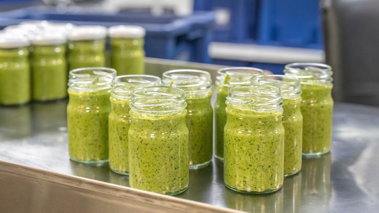 Jars of pesto on steel countertop