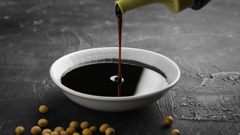 Soy sauce pouring into white bowl