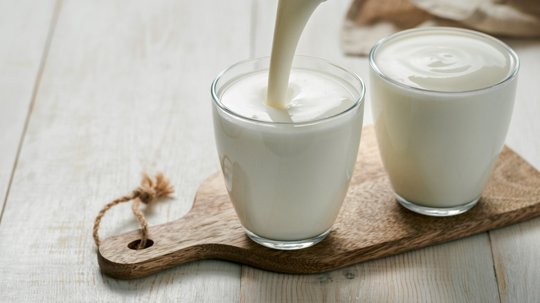 Yogurt in cups on wooden board