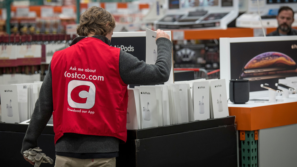 An employee organizes Apple Inc. AirPods for sale at a Costco Wholesale Corp. store