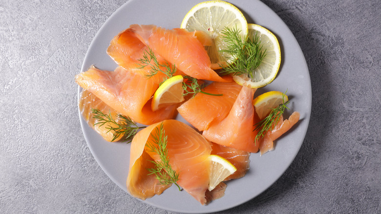 Plate of cold-smoked salmon with lemon wedges