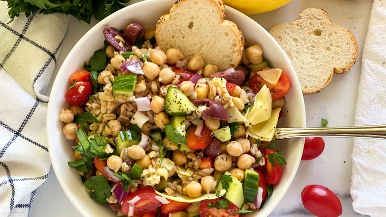 Salad of chickpeas, veggies, olives, and farro in a bowl