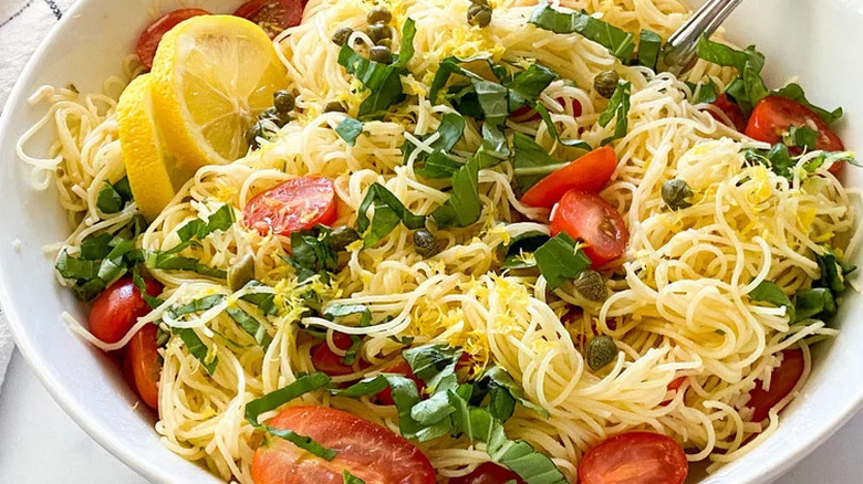 Thin noodles with basil, tomato, capers, and lemon slices 