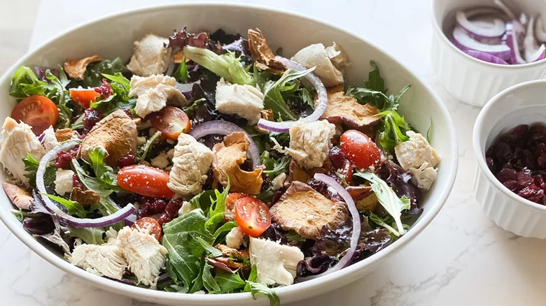Oval bowl of lettuce, chicken, and tomato salad