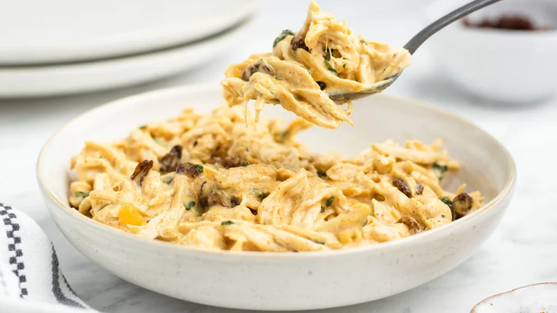 Shallow bowl of chicken salad with curry and raisins