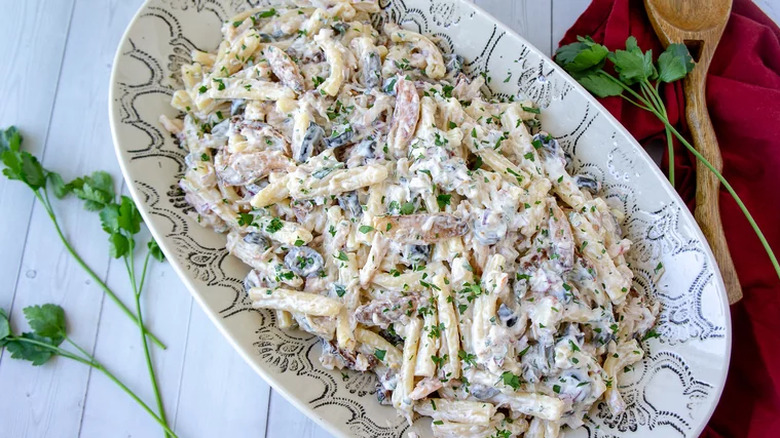 Oval serving dish with creamy pasta salad. 