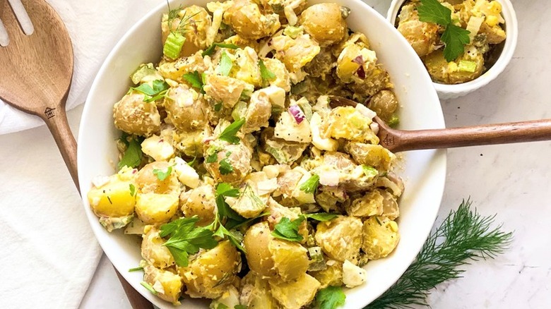 White bowl of potato salad with parsley