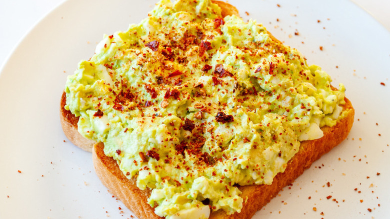 Bread with green egg salad and red spice