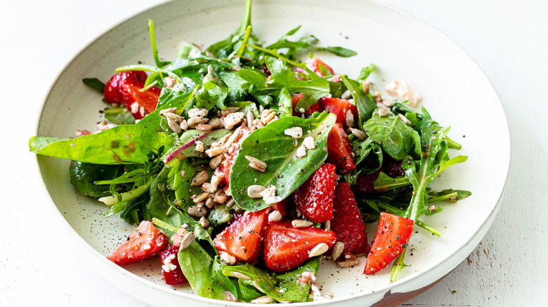 Salad of greens, strawberries, and sunflower seeds