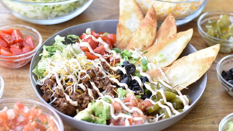 Bowl of ground beef, lettuce, tomatoes, and tortillas