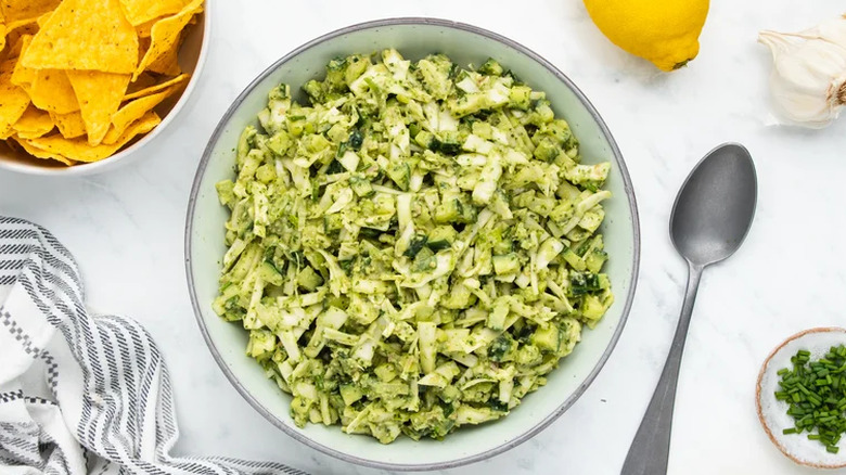 Spoon and bowl of cole slaw with green herb dressing