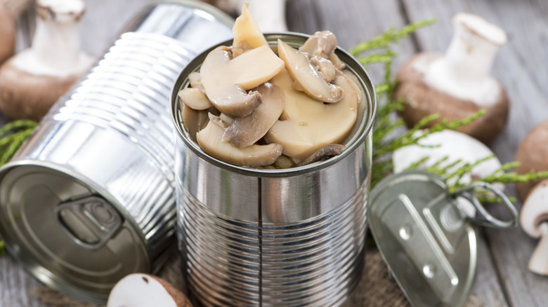 Canned mushrooms next to fresh mushrooms