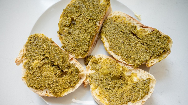 pesto spread on four slices of bread