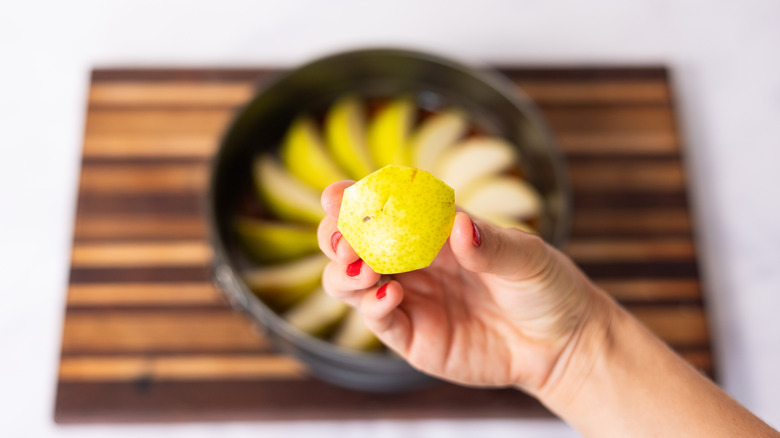 circle shaped cut of pear in hand