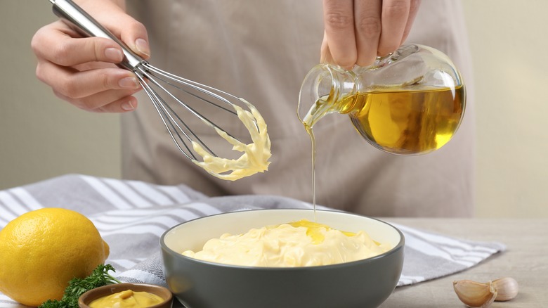 pouring oil into homemade mayonnaise