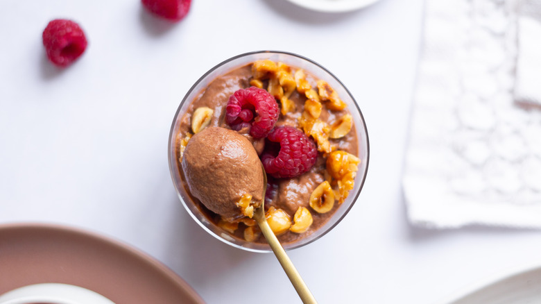 chocolate mousse in cup topped with raspberries  