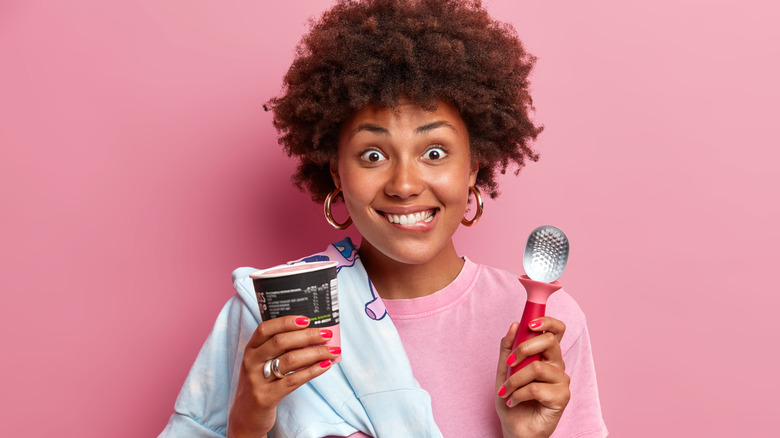 Person holding ice cream container