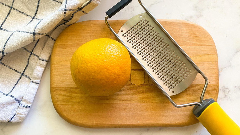 orange with grater and dishtowel