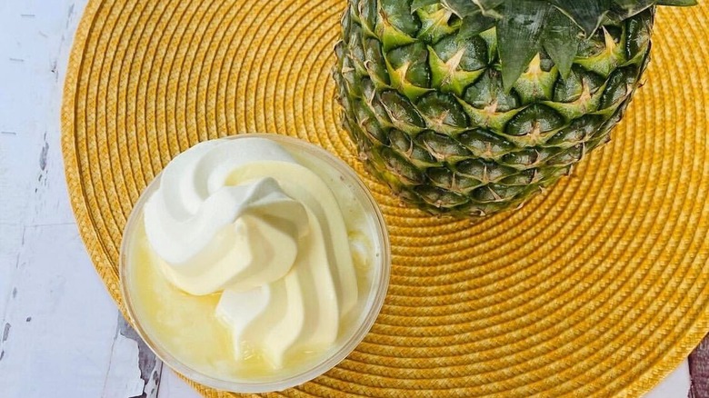 A pineapple and a whipped cream topped drink