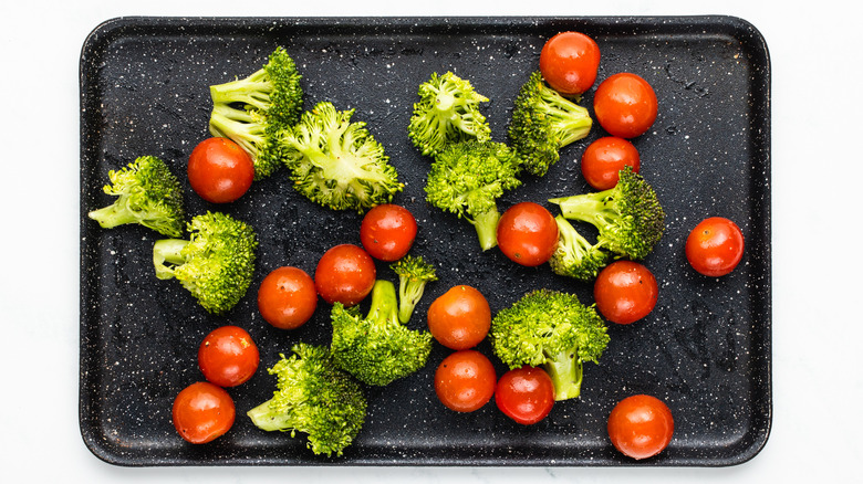 broccoli and cherry tomatoes on baking sheet