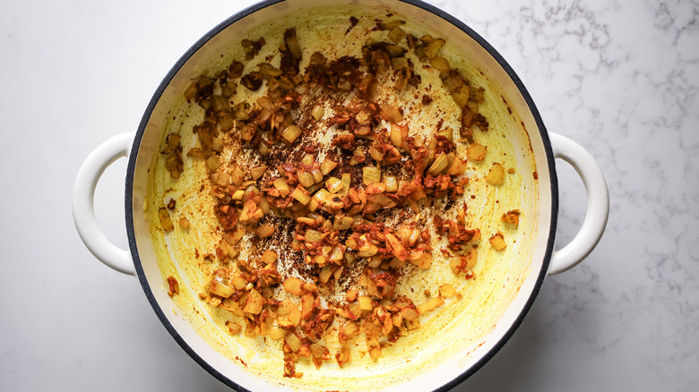 onion and tomato paste in Dutch oven