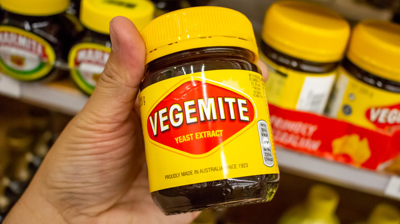 hand holding a container of Vegemite