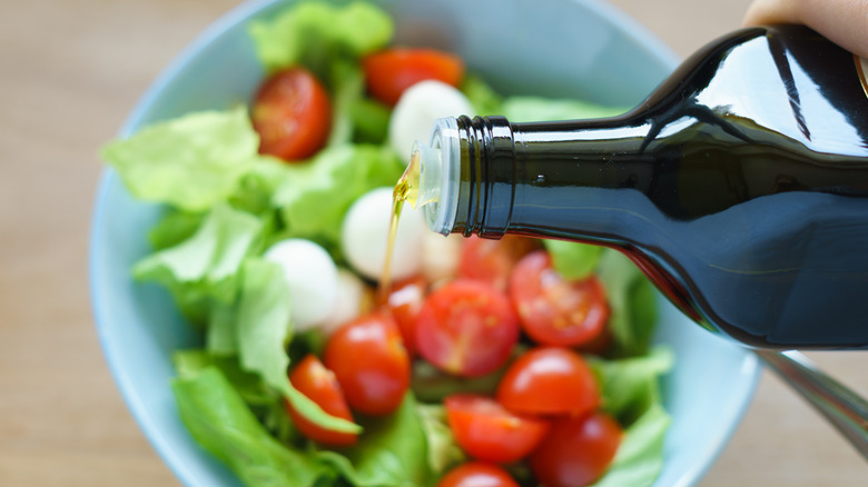 Olive oil being poured over salad