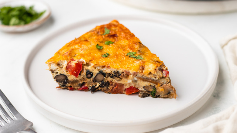 Slice of vegetable and black bean frittata on plate