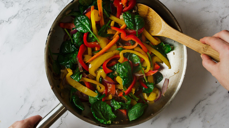 stirring vegetables in pan