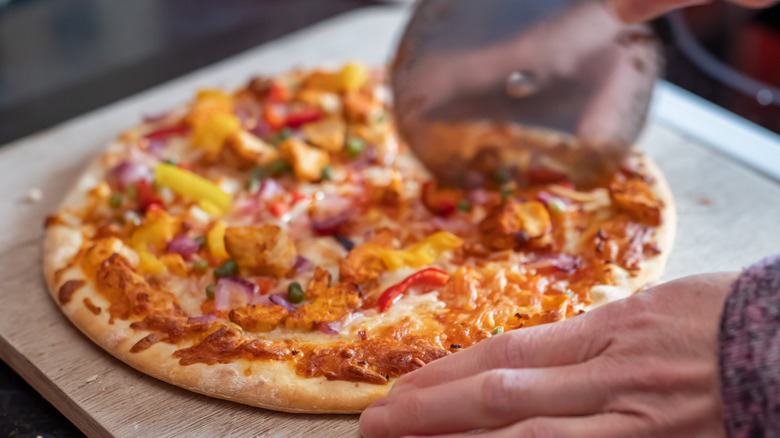 Person cutting pizza