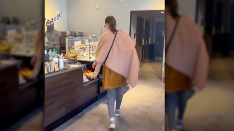 A screenshot of a woman at Starbucks