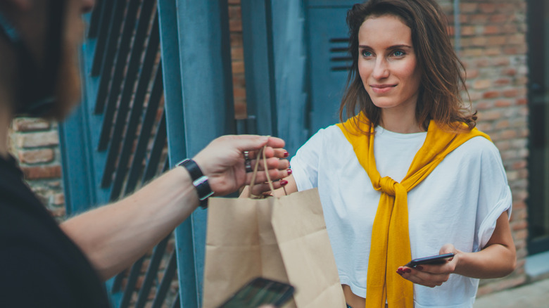 Smiling woman receiving takeout order