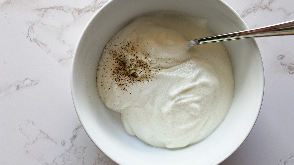 Greek yogurt in bowl with salt and pepper